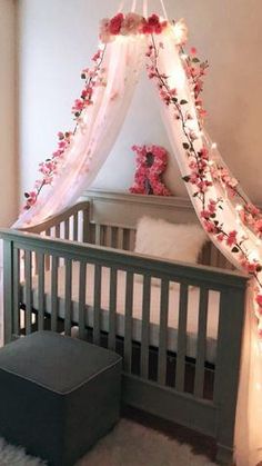 a baby's crib decorated with flowers and lights