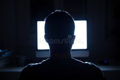 the silhouette of a man in front of a computer screen at night royalty images and stock photos