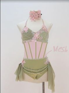 a mannequin wearing a green and pink dress with flowers on the bustle