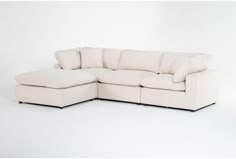 a white sectional couch with pillows on the top and bottom part, facing away from the camera