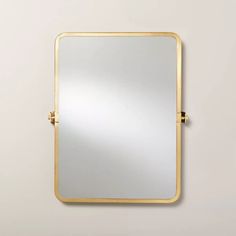 a gold framed mirror on a white wall with no one in the photo looking at it