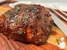 a piece of meat sitting on top of a wooden cutting board