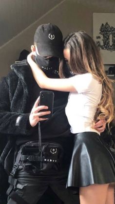 a man in a black jacket and skirt hugging a woman who is dressed as darth vader