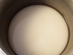 a metal pot filled with milk on top of a table