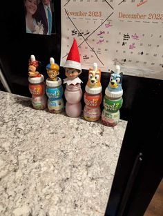 a group of baby bottles sitting on top of a counter next to a wall calendar