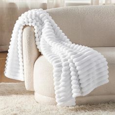 a white blanket is on the back of a couch