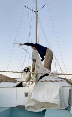 a man standing on top of a sail boat