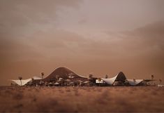 an airplane sitting on top of a dry grass field next to a desert like area