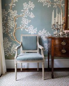 a chair sitting in front of a window next to a dresser