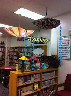 a library with umbrellas hanging from the ceiling and bookshelves filled with children's toys