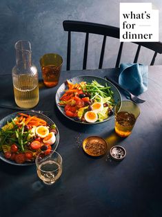 two plates of food sitting on top of a wooden table next to a glass vase