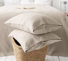 three pillows stacked on top of each other in a basket