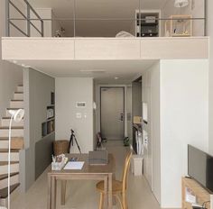 a living room and dining area with stairs leading up to the second floor in an apartment