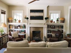 a living room with two couches and a fire place in the middle of it