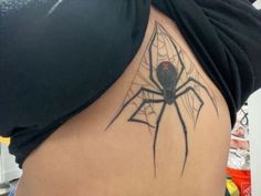 a woman with a spider tattoo on her stomach