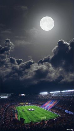 a full moon is seen above a soccer field in the dark night sky with clouds