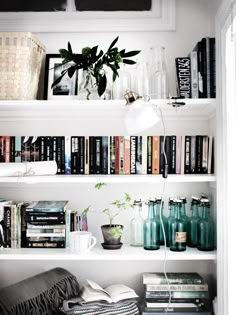 a book shelf filled with lots of books and vases on top of it's shelves