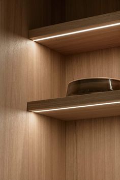 a wooden shelf with two lights on it and a hat hanging from the wall in front of it