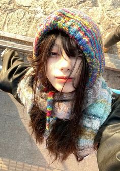 a young woman wearing a multicolored hat and scarf