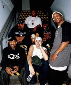 a group of young men sitting next to each other on top of stairs with one man holding a cell phone