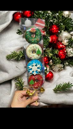 a person is holding some christmas decorations in their hand