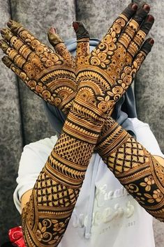 two hands that are covered in henna and some sort of design on the arm