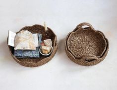 two baskets with items in them sitting on a white table top next to each other