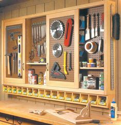 a workbench with lots of tools hanging on the wall