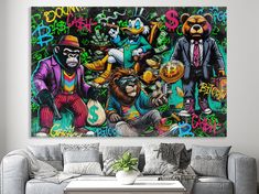 a living room with a couch and painting on the wall above it that has graffiti all over it