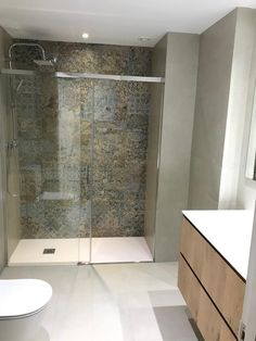 a bathroom with a walk in shower next to a toilet