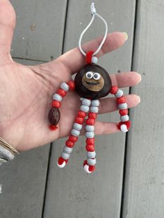 a hand holding a beaded spider ornament