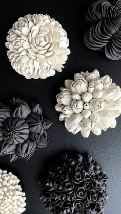 several different types of flowers are arranged on a black surface with white and gray petals