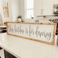 a sign that says this kitchen is for dancing on top of a white countertop