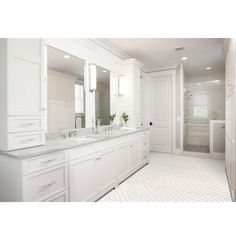 a large bathroom with two sinks, mirrors and a walk - in shower next to a tiled floor