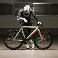 a man in a wet suit and helmet riding a bike with his hands on the front wheel