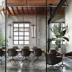 an industrial style office with leather chairs and tables