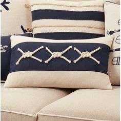 the pillows on the couch are decorated with nautical knots and marine rope, along with other decorative items