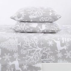 two pillow cases with deer and snowflakes printed on them, one is white