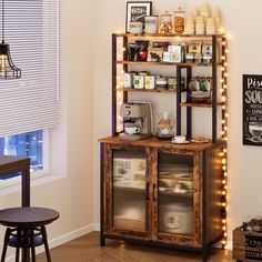 a wooden shelf with lights on it next to a chair and table in front of a window