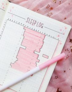 a pink pen laying on top of a notebook