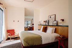 a bed sitting in a bedroom next to a wooden headboard and foot board with pictures on the wall above it