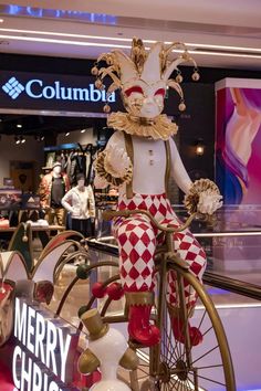 a statue of a clown riding a bike in a mall