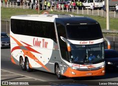 an orange and white bus driving down a street next to other cars on the road