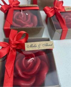 three boxes with red roses in them and a ribbon tied around the top one box has a name tag on it