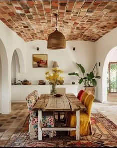 a dining room table with chairs and a bench in the middle of an open floor plan