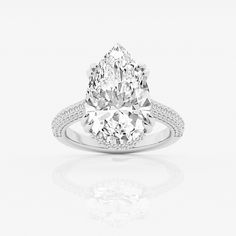 a pear shaped diamond ring with diamonds on the shoulders and sides, set in white gold