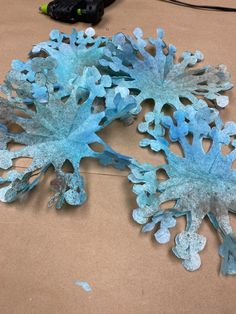 two blue corals sitting on top of a brown table next to a black cord