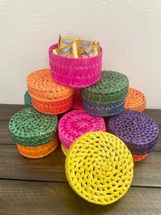 a stack of colorful baskets sitting on top of a wooden table