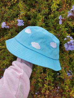 "Do you love to have your head in the clouds? This cloudy sky bucket hat is a Magical Girl Bella original art and design, featuring embroidery of 5 clouds around the blue bucket hat. Bucket Hat Inside circumference: approximately 23\" - the standard adult hat size This listing has limited quantity that are ready to ship. **MORE DESIGNS AVAILABLE ON MY WEBSITE MAGICALGIRLBELLA.SQUARE.SITE" Bucket Hat Aesthetic, Blue Bucket Hat, Rave Ideas, Hat Aesthetic, Postcard Book, Head In The Clouds, Cloudy Sky, Magnolia Pearl, In The Clouds