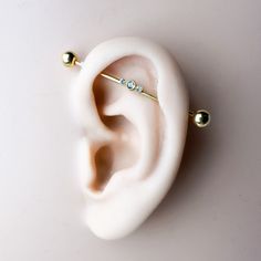 a pair of ear piercings sitting on top of a white surface